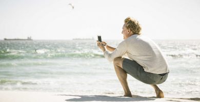 Un hombre toma una fotografía con la cámara del móvil en la playa